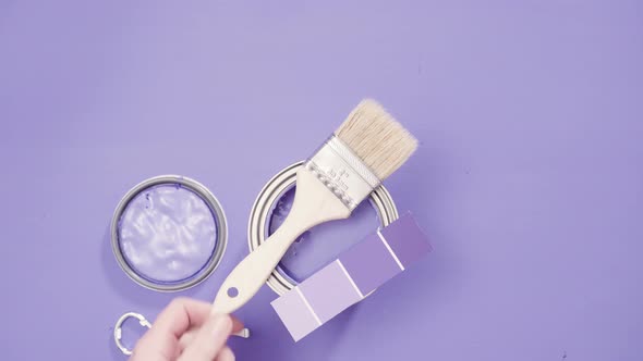 Close up of metal paint can with purple paint and paint swatch.