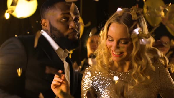 Mixed-Race Couple Dancing at Party Under Falling Confetti, Entertainment