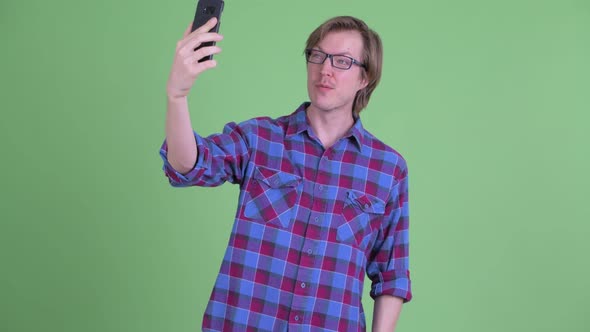 Happy Young Handsome Hipster Man Taking Selfie and Giving Thumbs Up