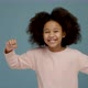Portrait of cheerful little girl with curly hair smiling funny and dancing joyfully - VideoHive Item for Sale
