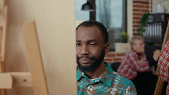 Portrait of African American Man Drawing on Canvas in Art Class