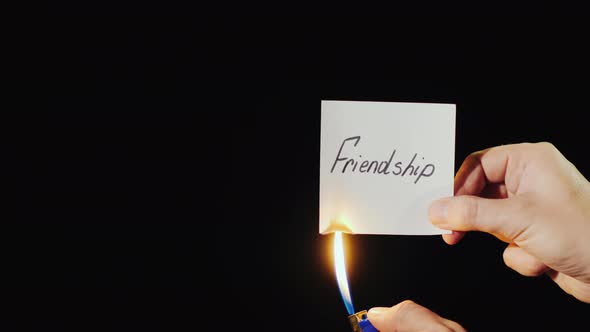 Man Burns a Paper with the Inscription Friendship