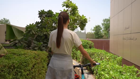 Woman with a Bike in the Park