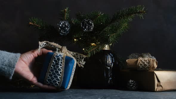 Female Hand Puts Christmas Present on Table