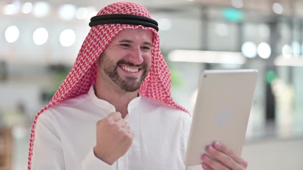 Excited Businessman Celebrating Success on Tablet 