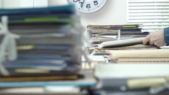 Employee working in the office and piles of paperwork