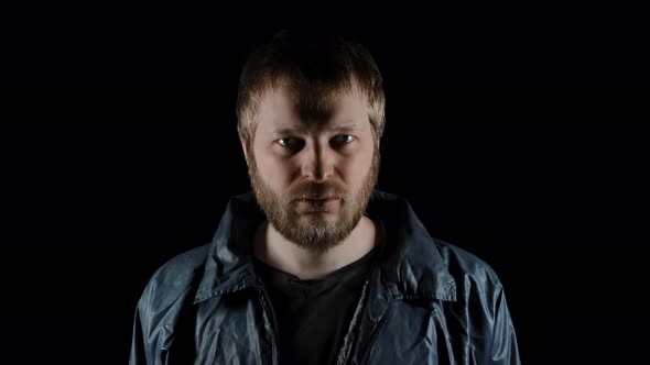 Closeup Portrait of Bearded Homeless on Dark Background