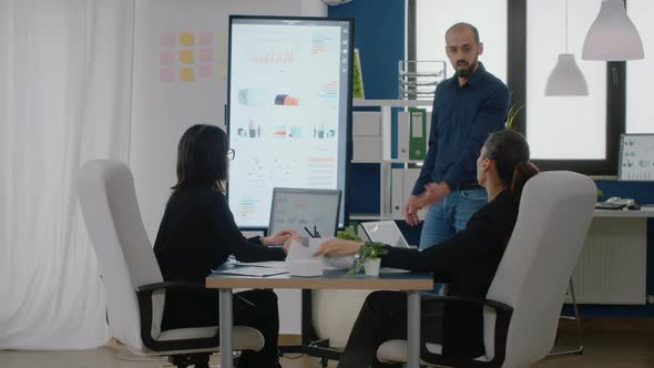 Man Pointing at Television with Chart Presentation