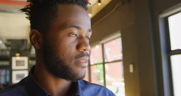 Front view of happy young black businessman looking at camera in a modern office 4k