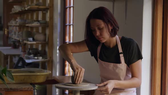 Young female potter working in her studio