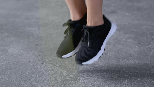 Close-Up of Women's Feet in Sports Shoes Jumping Rope Dressed in Sportswear Black Top 