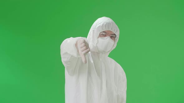 Asian Male Wear Protective Uniform PPE And Showing Thumbs Down, Unlike In Green Screen Studio