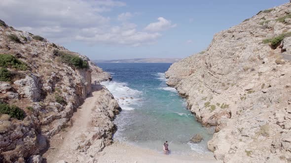 Drone flies forward between narrow rocky canyon nature and blue sea. Volcanic archipelago