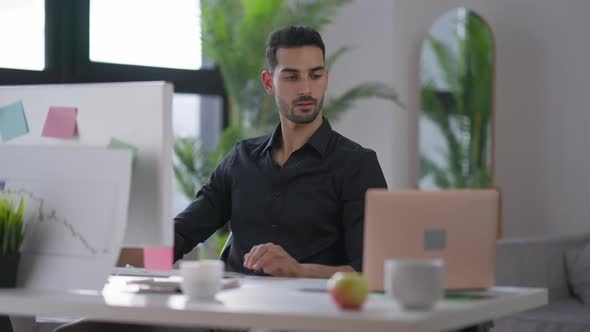 Portrait of Handsome Busy Man Messaging Online on Computer and Laptop in Home Office