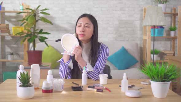 Portrait of an Asian Young Woman Using Makeup in the Living Room