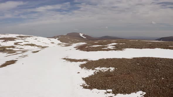 Scotland Mountain Plateau Covered in Snow Drone with Person Walking Shot