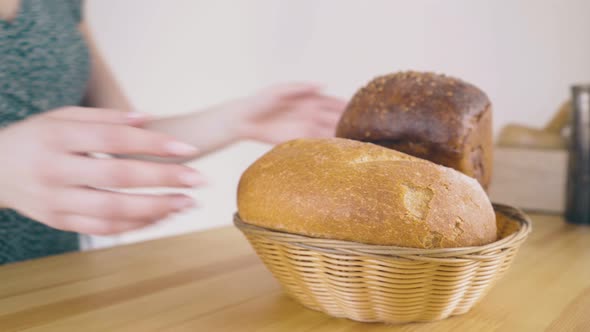 Girl Takes Away Loaves of Bread From Table in Kitchen