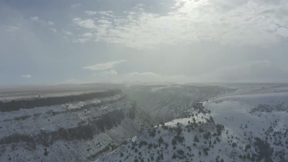 Wide panning drone shot of snowy canyon