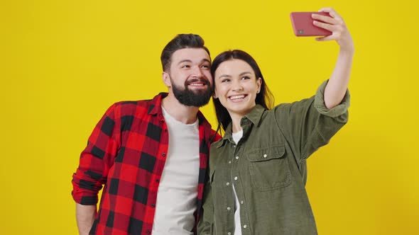 Funny Couple Making Selfie on Yellow Background