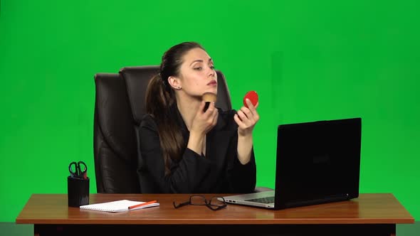 Business Woman at Workplace Makes Make-up and Applying Powder on Face Skin Looking in a Red Mirror