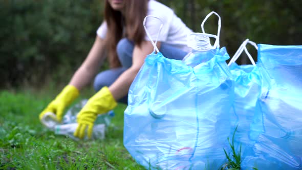 a Young Female Volunteer Cleans Garbage in Nature