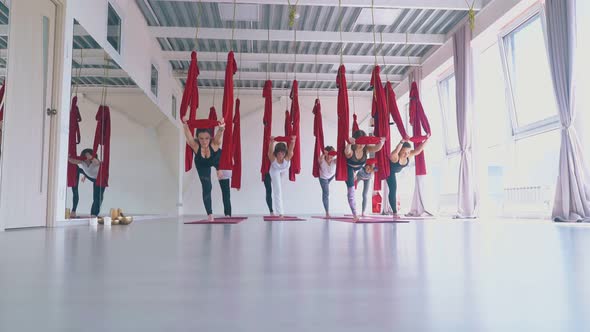 Concentrated Ladies Practice Anti-gravity Yoga Warrior Asana