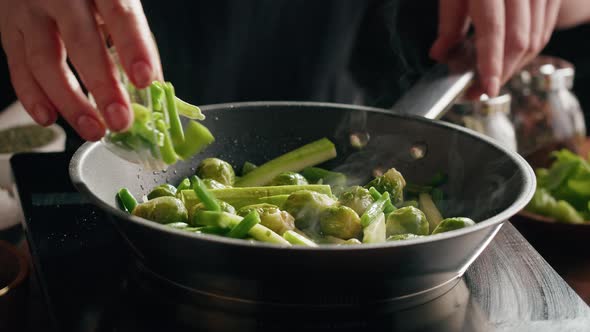 Chef Frying Green Brussels Sprouts Cabbage in Pan Closeup