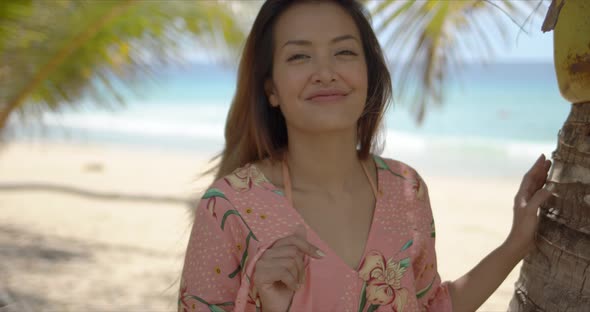 Delighted Ethnic Woman Touching Palm Leaves