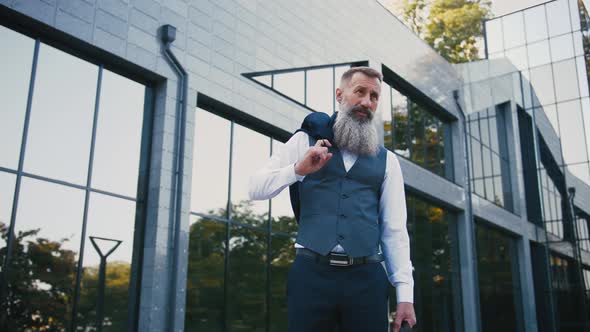 Portrait of Handsome Bearded Mature Man in Suit Outdoors on Modern Building Background During Sunny