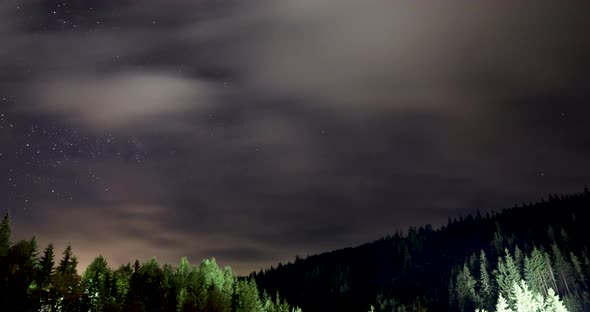 Timelapse Of Clouds And Milky Way Moving Over The Mountains And Forest At Night.