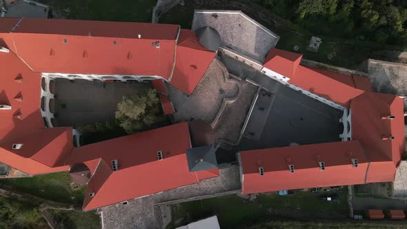 Aerial Top Down View of Medieval Castle on Mountain in Small European City at Cloudy Autumn Day