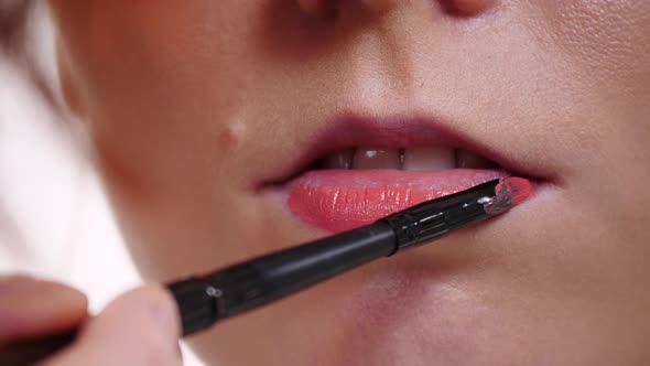Makeup Artist Applying Lip Gloss To Model Lips