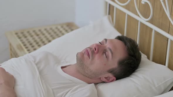 Attractive Young Man Sleeping in Bed Peacefully