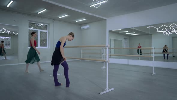 Wide Shot Slim Graceful Ballerina Adjusting Leggings Greeting Young Woman Entering Dance Studio