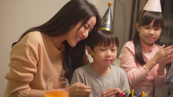 Asian young family enjoy moment having birthday party for young little child together at home.