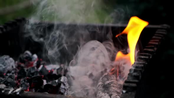 Black Charcoal Burns with Bright Fire Lying in Iron Brazier