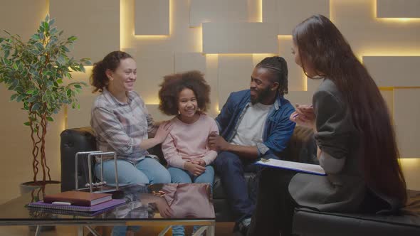 Joyful Multiethnic Parents with Daughter Thanking Family Counselor for Help