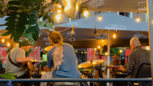 Blurry Band is Playing at a Beautiful Evening Outdoors Bar at a European City