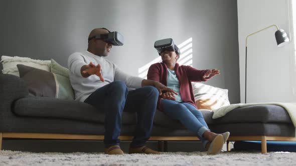 Happy african american senior couple wearing vr headset and having fun