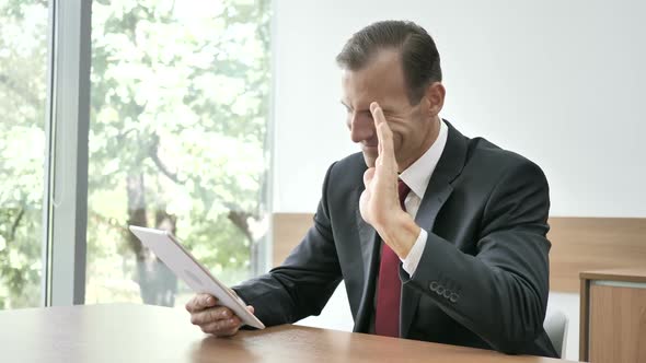 Online Video Chat on Tablet By Businessman Sitting on Couch