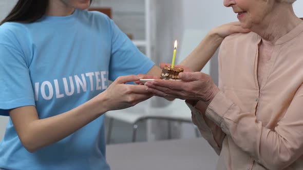 Young Volunteer and Aged Female Celebrating Birthday, Retiree Blowing Candle