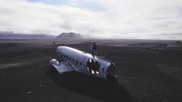 Breathtaking Drone Shot of Two Tourists on Top of Solheimasandur Plane Wreck