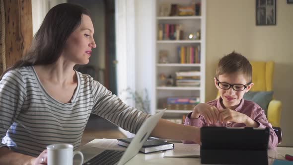 Young Mother and Son Spend Good Time at Table with Gadgets During Selfisolation at Home Spbd