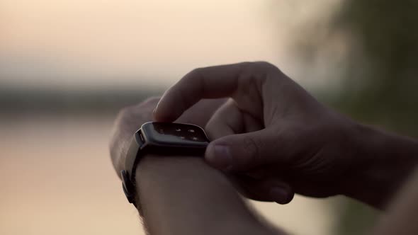 Close Up Touch Screen Wearable Technology Smart Band On Wrist Outdoor. Man Using Smart Watch.
