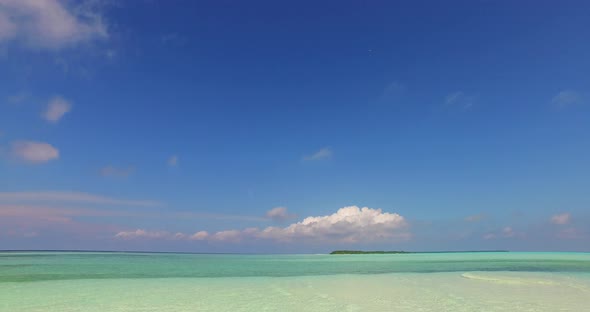 Luxury drone tourism shot of a summer white paradise sand beach and blue sea background in 4K