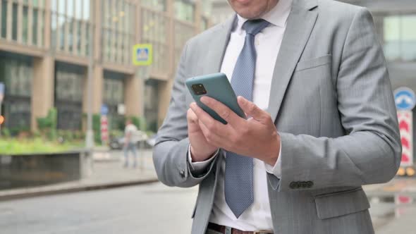 Close Up of Male Hands Using Smartphone while Walking on Street