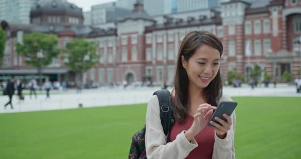 Woman travel in Tokyo and use of mobile phone at Tokyo station