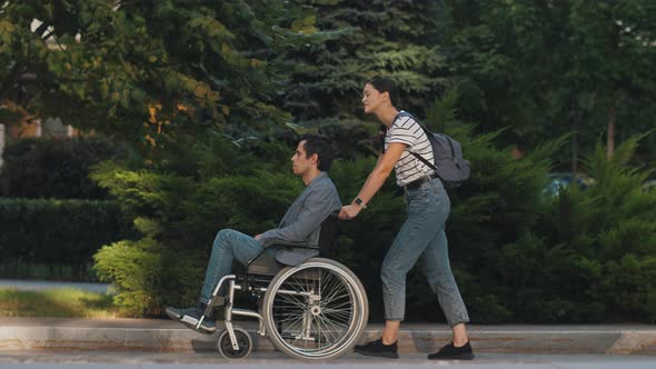 Man in Wheelchair and His Wife Outdoors