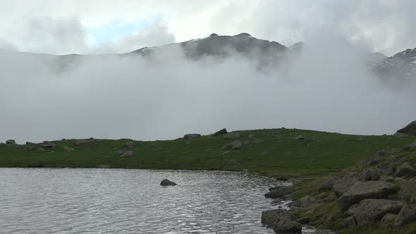 Clouds Pass Through the Valley Next to the High Altitude Alpine Lake