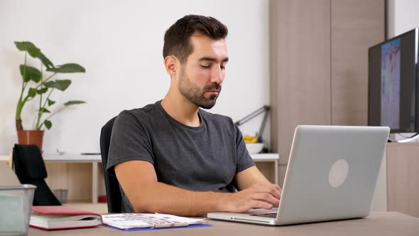 Man Typing on the Notebook in His Living Room